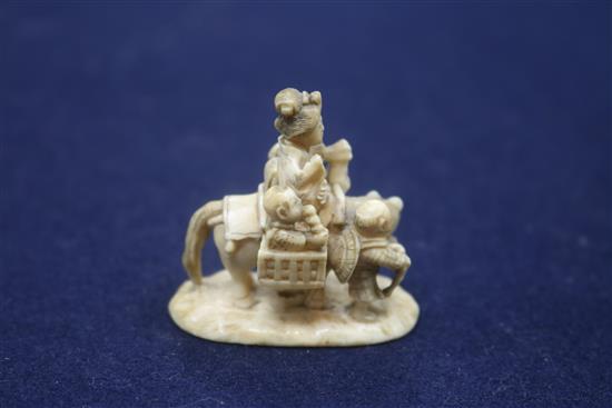 A Japanese carved ivory group of a family travelling with a donkey, height 43mm.